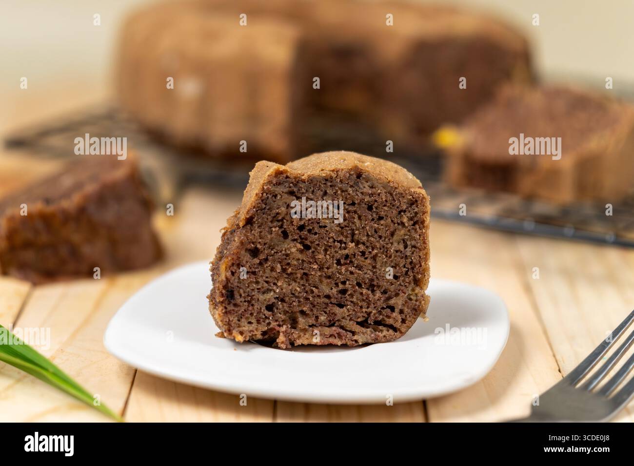 Fette di torta al cioccolato alla banana disposte in modo ordinato, mostrando una consistenza umida e un sapore ricco in un'illuminazione soffusa Foto Stock