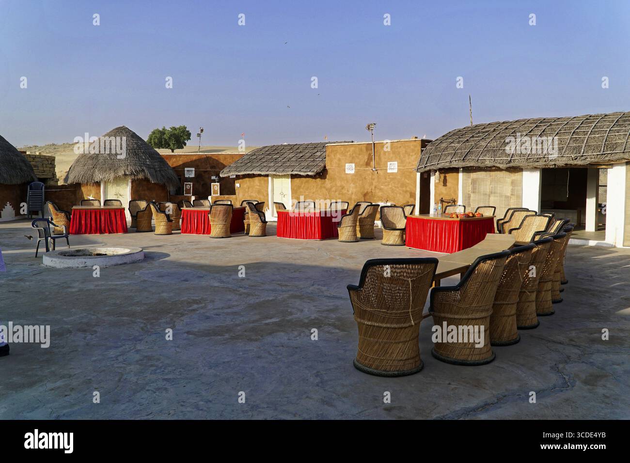 Villaggio turistico di tenda nel deserto del Thar, vicino a Jaisalmer, Rajasthan, India del Nord, un cortile aperto con edifici tradizionali, tavoli arredati e ch Foto Stock