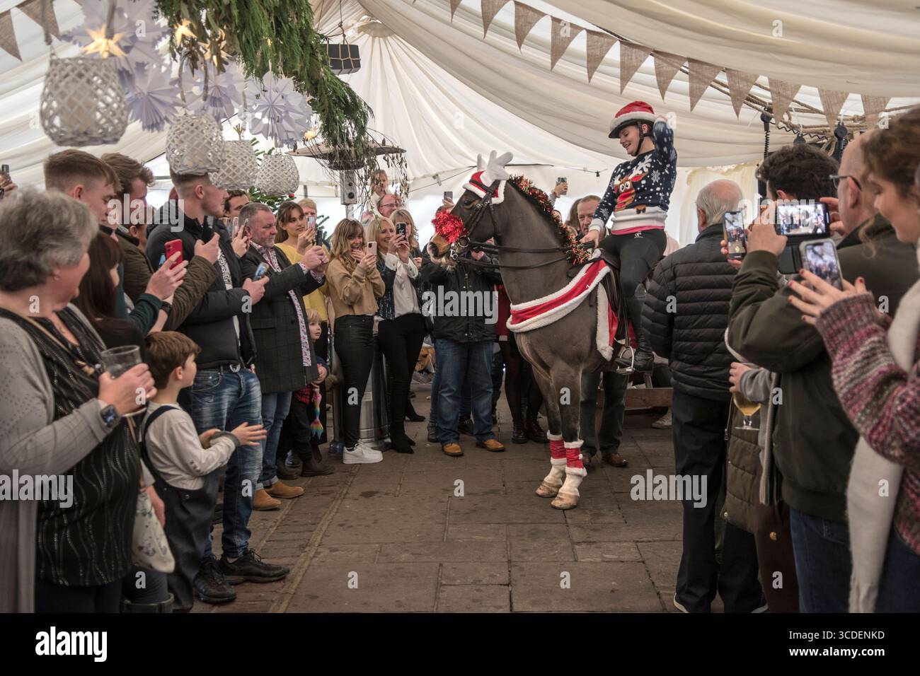 Il Fox Inn, Bucks Green, Sussex, il giorno di Natale ogni anno un cavallo viene cavalcato attraverso il pub dal giardino anteriore al retro lungo un sentiero in mattoni per mantenere aperto un antico diritto di passaggio. Il cavallo si ferma al bar per salutare il personale del bar e poi fuori dalla porta sul retro e in un marchio eretto per l'occasione dove molti locali si godono un drink prima di pranzo di Natale. Bucks Green, Sussex, Inghilterra 25 dicembre 2022 UK 2020s HOMER SYKES Foto Stock