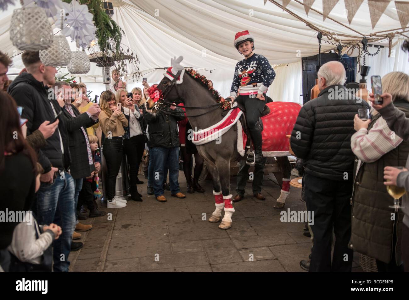 Il Fox Inn, Bucks Green, Sussex, il giorno di Natale ogni anno un cavallo viene cavalcato attraverso il pub dal giardino anteriore al retro lungo un sentiero in mattoni per mantenere aperto un antico diritto di passaggio. Il cavallo si ferma al bar per salutare il personale del bar e poi fuori dalla porta sul retro e in un marchio eretto per l'occasione dove molti locali si godono un drink prima di pranzo di Natale. Bucks Green, Sussex, Inghilterra 25 dicembre 2022 UK 2020s HOMER SYKES Foto Stock