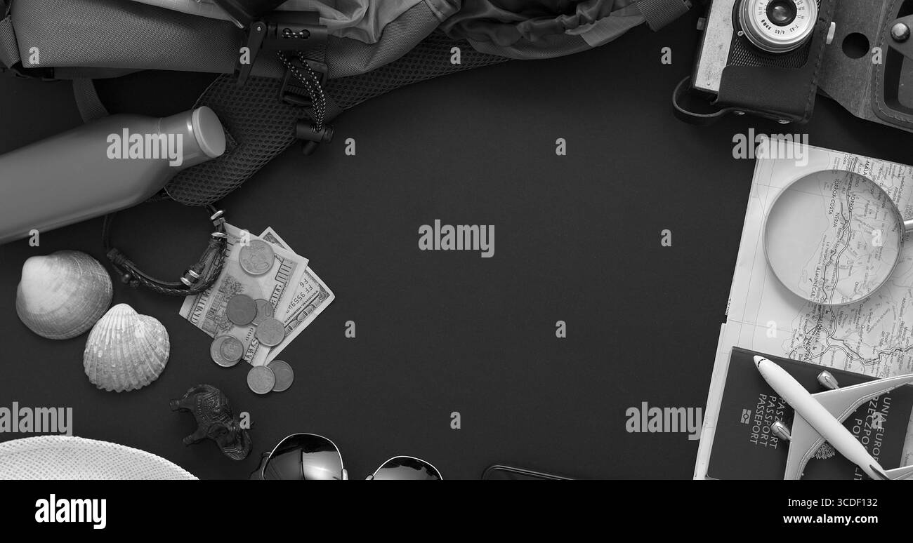 Concetto di viaggio e turistico. Accessori per vacanze e viaggi su sfondo nero. Con mappa, fotocamera, passaporto, denaro, zaino, smartphone. Piatto Foto Stock