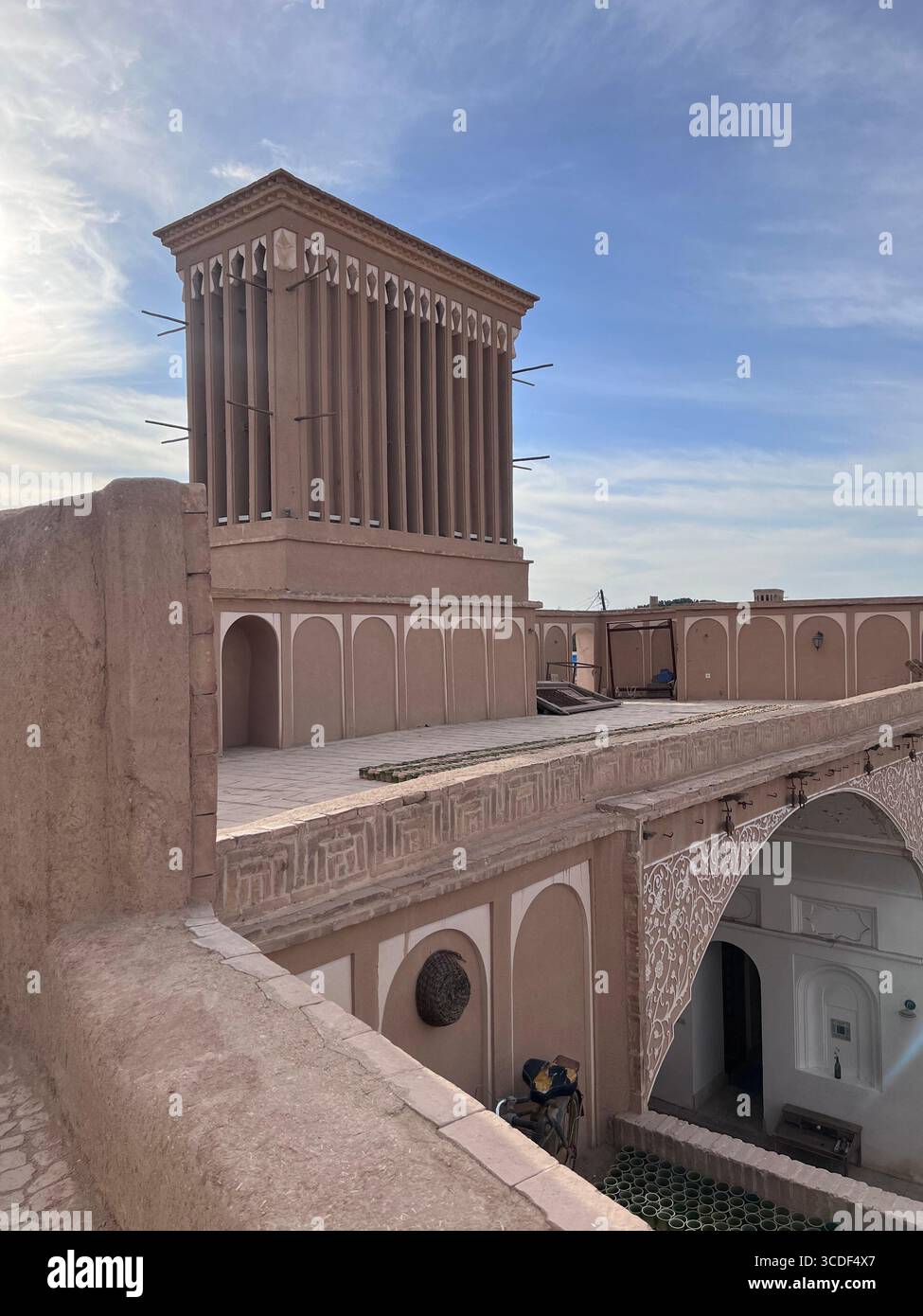Storico generatore di vento che si innalza sopra il cortile di una casa tradizionale a Yazd, Iran, un capolavoro dell'architettura del deserto persiano. Foto Stock Storico generatore di vento che si innalza sopra il cortile di una casa tradizionale a Yazd, Iran, un capolavoro dell'architettura del deserto persiano. Foto Stock