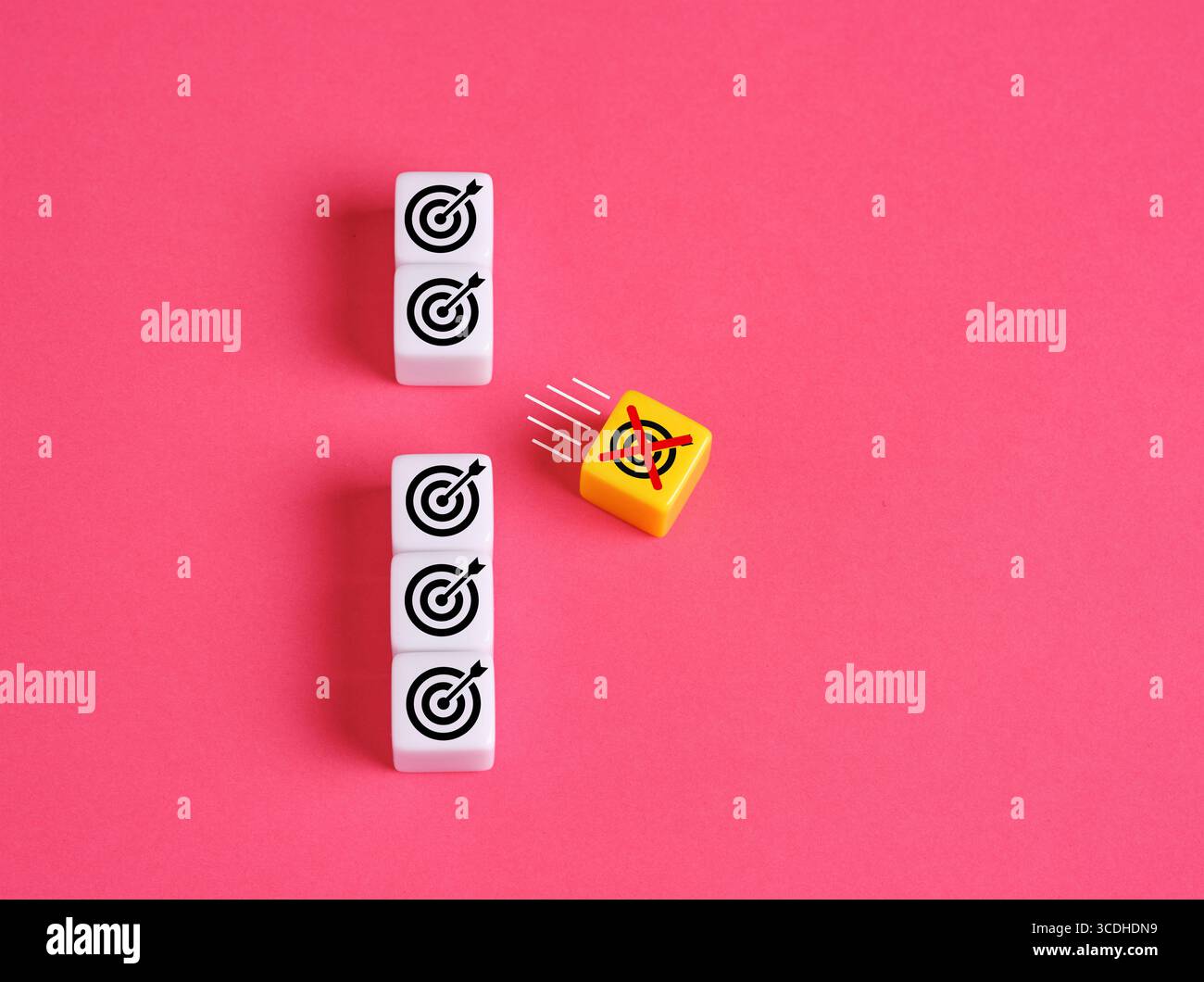 Spostamento obiettivo. Eliminare obiettivi irrealistici o irraggiungibili. Cubo giallo con il simbolo del bersaglio che si allontana dagli altri goal sul backgroun rosa Foto Stock