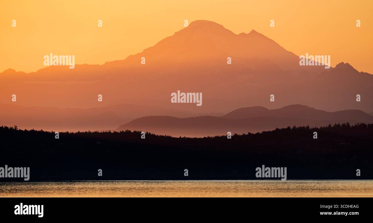 Monte Baker all'alba visto attraverso lo stretto di Haro da Mount Tolmie vicino a Victoria, Columbia Britannica, Canada. Foto Stock
