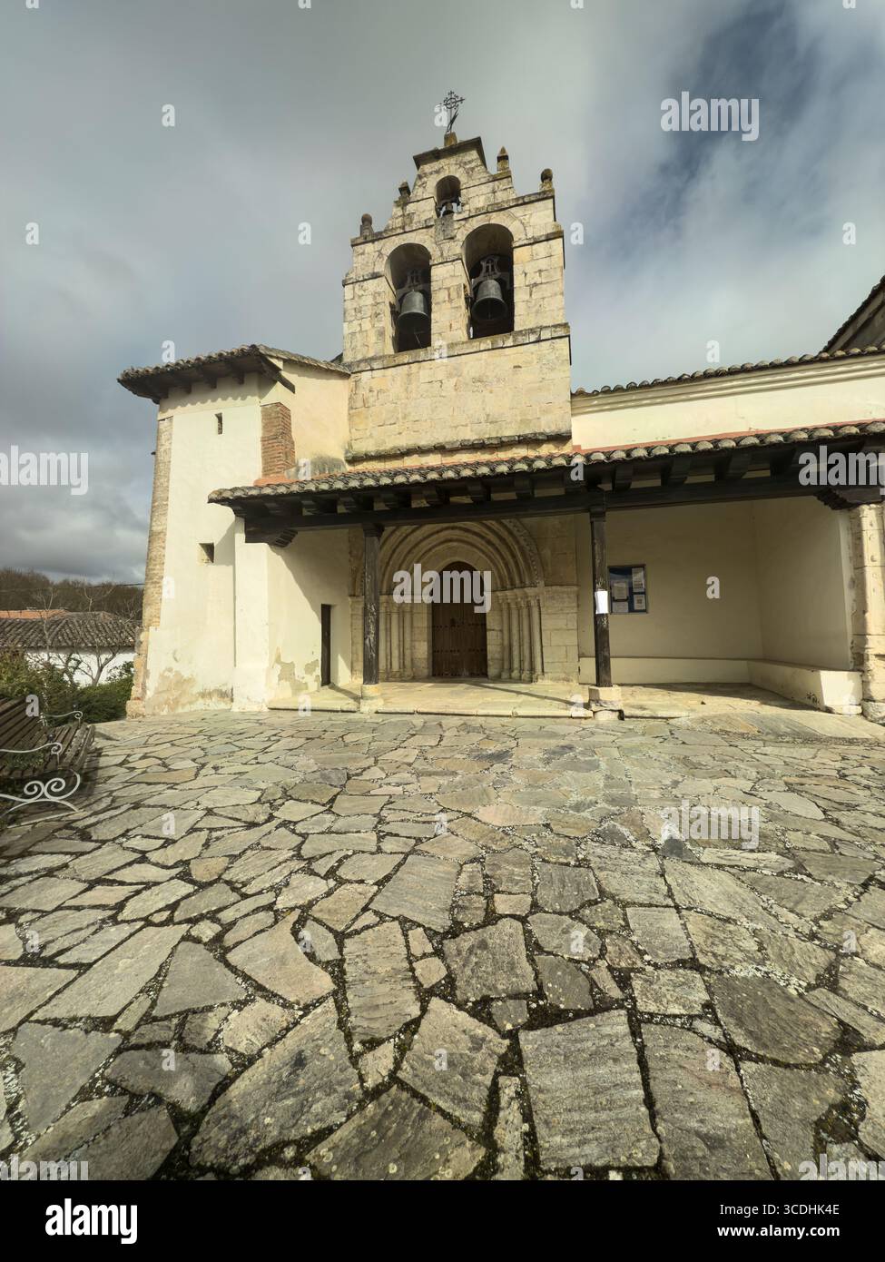 Storica chiesa romanica con campanile in pietra, porta ad arco e pareti bianche. Foto Stock