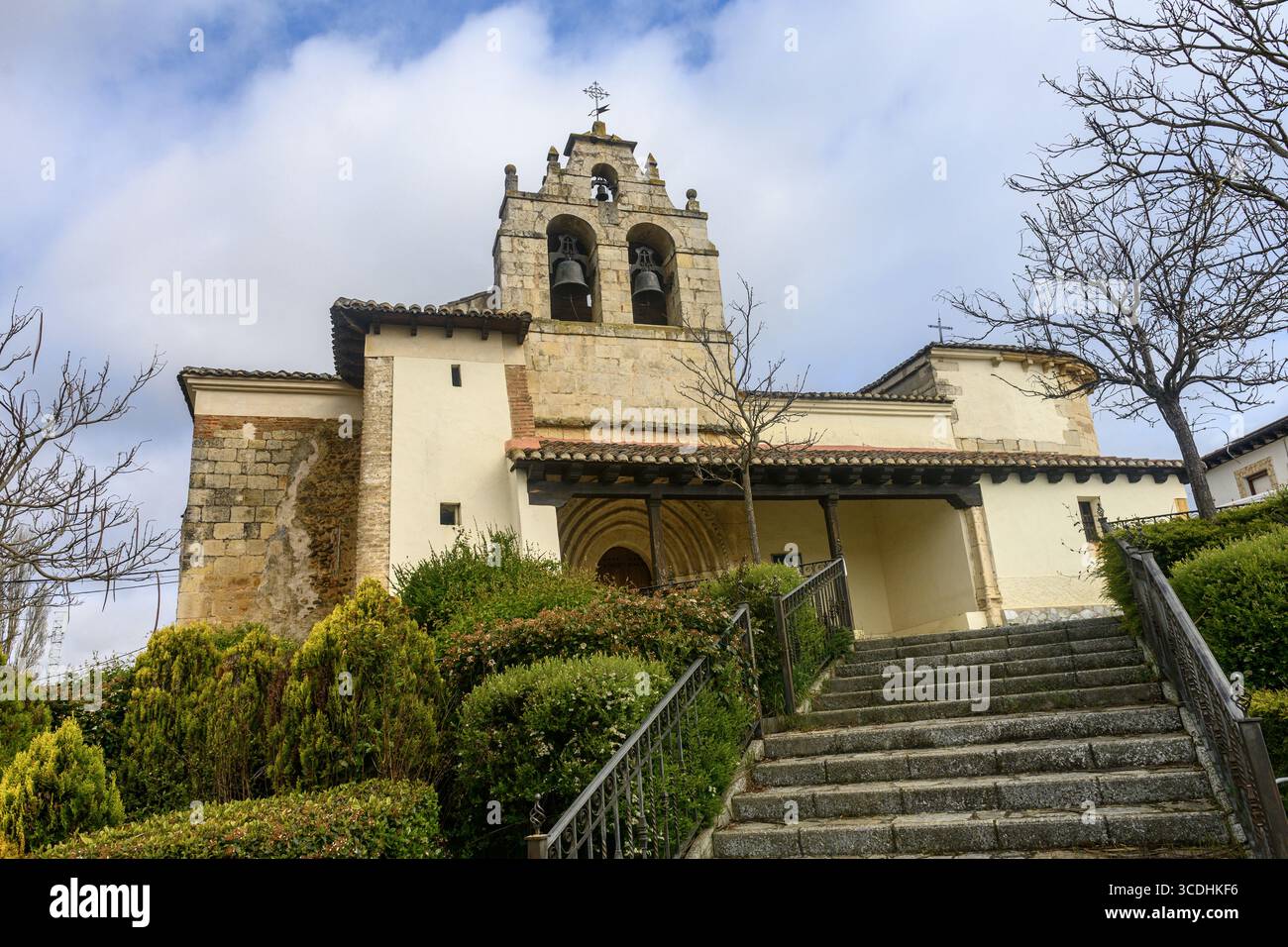 Storica chiesa romanica con campanile in pietra, porta ad arco e pareti bianche. Foto Stock