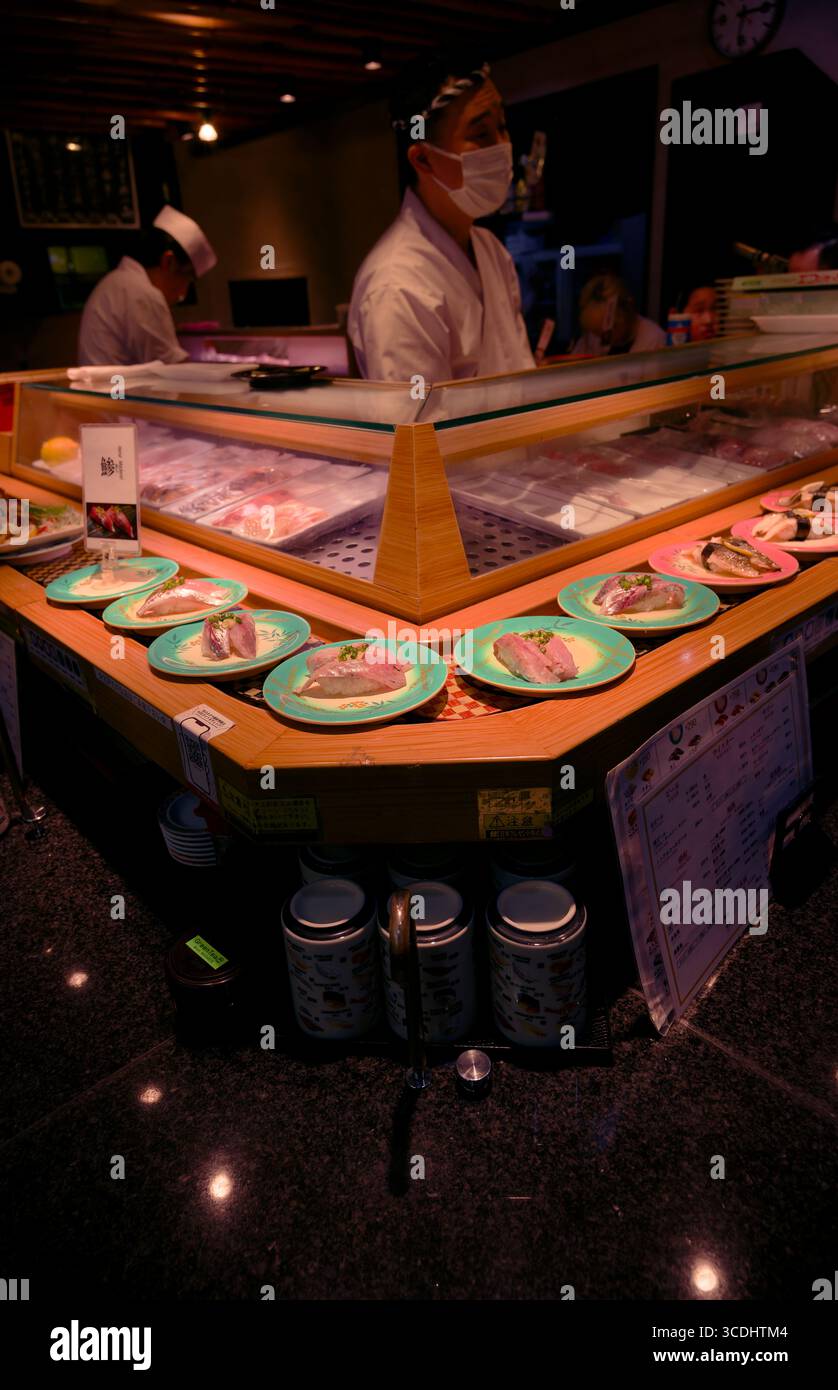 Chef di sushi che preparano piatti freschi in un ristorante di sushi conveyor belt ad Asakusa, Tokyo Foto Stock