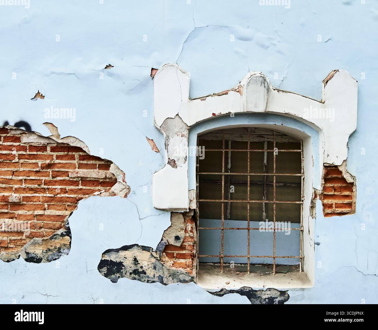 Muro blu incrinato del vecchio edificio e finestra barrata Foto Stock