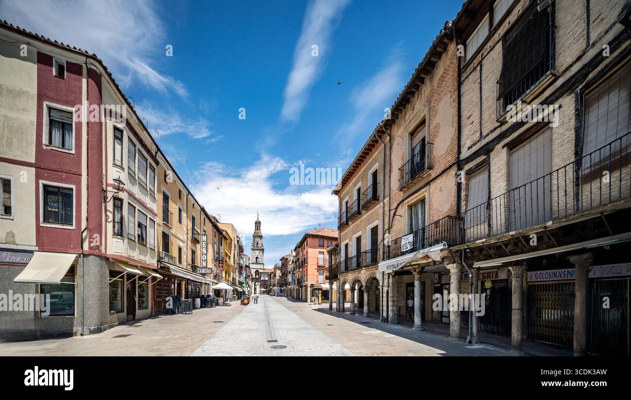 I visitatori apprezzano Plaza Mayor a Toro, mentre la Torre dell'Orologio li accoglie nella città medievale fortificata sotto un cielo limpido. Foto Stock