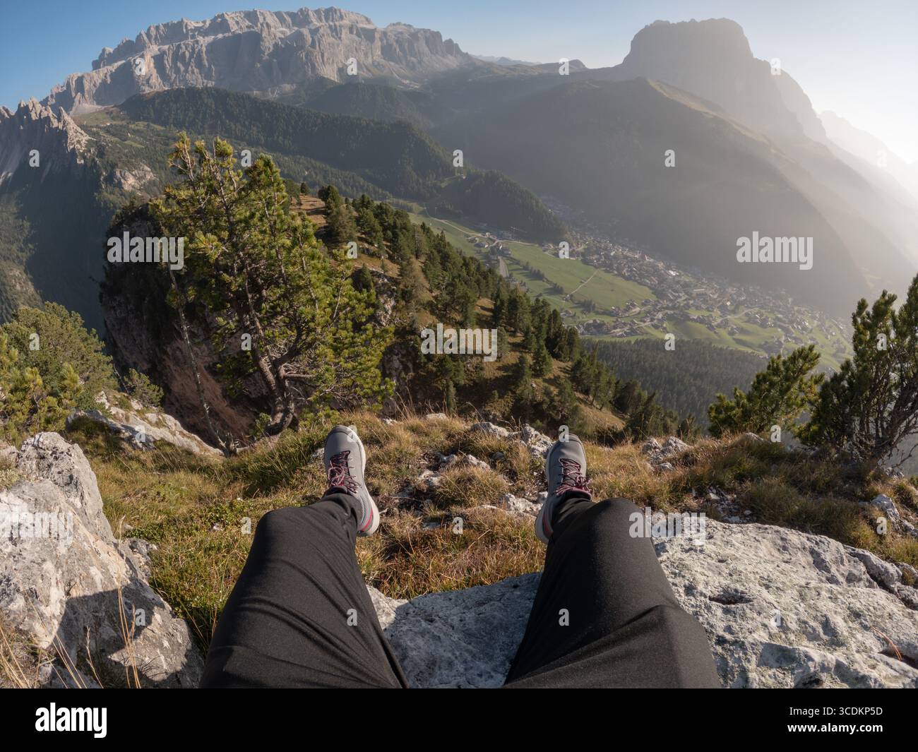 Primo piano con le scarpe da trekking, uomo seduto sul bordo delle montagne delle Alpi Foto Stock