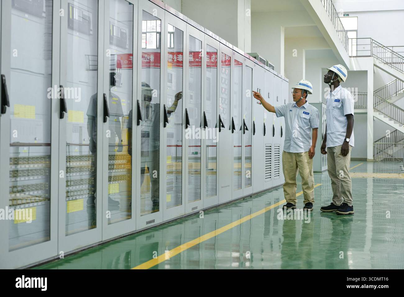 (250813) -- DUBREKA (GUINEA), 13 agosto 2025 (Xinhua) -- tecnici cinesi e guineani ispezionano le attrezzature presso la centrale idroelettrica Kaleta di Dubreka, Guinea, il 24 aprile 2025. Sul fiume Konkoure che scorre giù dagli altopiani di Fouta Djallon nella Guinea centrale, l'impressionante struttura della centrale idroelettrica di Kaleta si riflette nelle acque. La struttura ha fornito elettricità stabile alla capitale nazionale di Conakry e ai villaggi delle montagne settentrionali, ora presenti sulla banconota da 000 franchi della Guinea, che mostra un netto contrasto con la scena dieci anni fa. Nell'agosto 2015, la Kaleta Foto Stock
