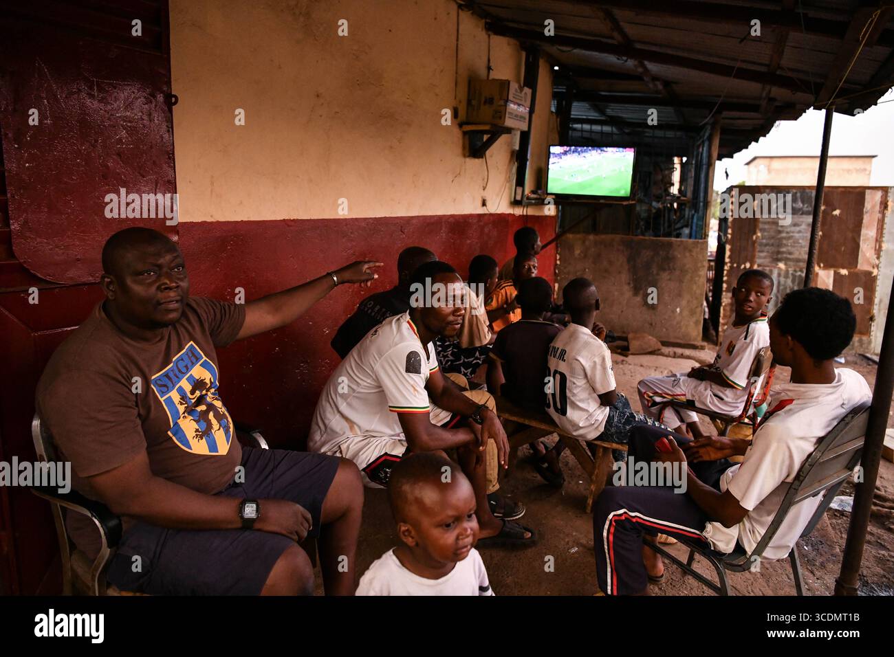 (250813) -- CONAKRY, 13 agosto 2025 (Xinhua) -- i residenti locali guardano la televisione in una comunità di Conakry, Guinea, il 26 aprile 2025. Sul fiume Konkoure che scorre giù dagli altopiani di Fouta Djallon nella Guinea centrale, l'impressionante struttura della centrale idroelettrica di Kaleta si riflette nelle acque. La struttura ha fornito elettricità stabile alla capitale nazionale di Conakry e ai villaggi delle montagne settentrionali, ora presenti sulla banconota da 000 franchi della Guinea, che mostra un netto contrasto con la scena dieci anni fa. Nell'agosto 2015, la centrale idroelettrica di Kaleta, costruita dalla China Int Foto Stock