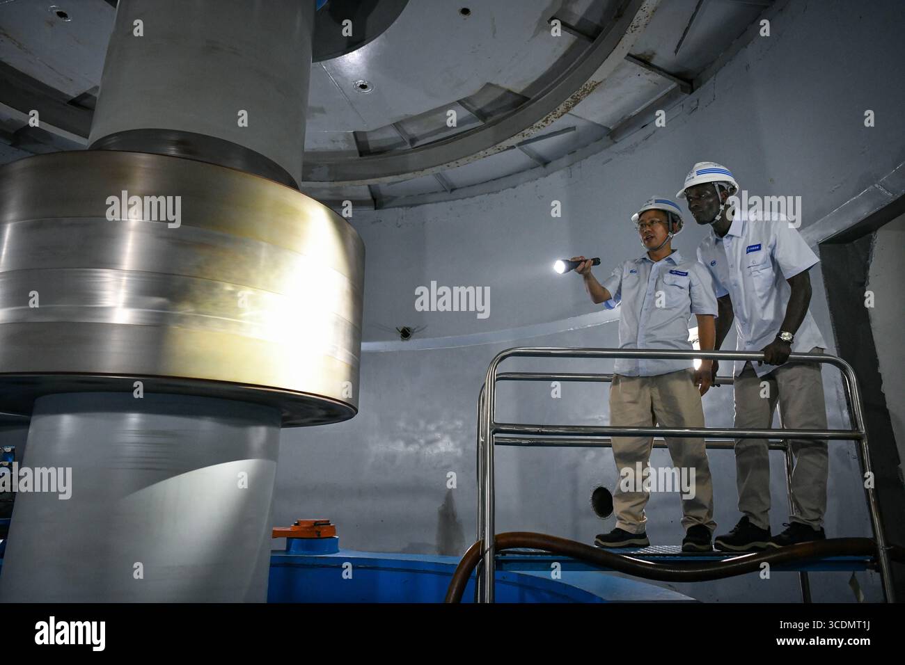 (250813) -- DUBREKA (GUINEA), 13 agosto 2025 (Xinhua) -- tecnici cinesi e guineani ispezionano le attrezzature presso la centrale idroelettrica Kaleta di Dubreka, Guinea, il 24 aprile 2025. Sul fiume Konkoure che scorre giù dagli altopiani di Fouta Djallon nella Guinea centrale, l'impressionante struttura della centrale idroelettrica di Kaleta si riflette nelle acque. La struttura ha fornito elettricità stabile alla capitale nazionale di Conakry e ai villaggi delle montagne settentrionali, ora presenti sulla banconota da 000 franchi della Guinea, che mostra un netto contrasto con la scena dieci anni fa. Nell'agosto 2015, la Kaleta Foto Stock
