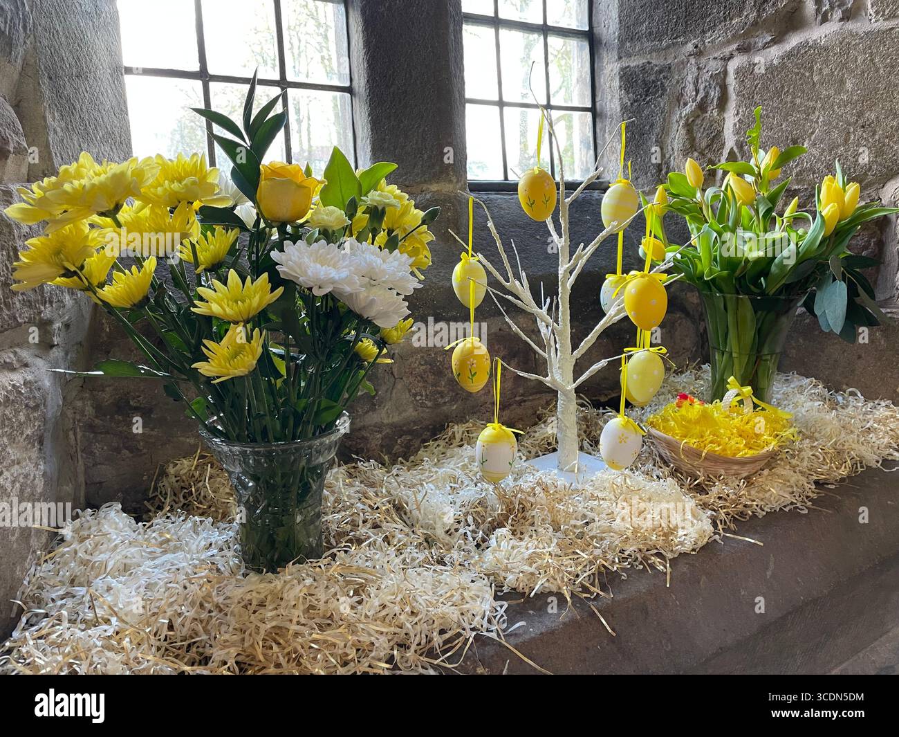 Fiori primaverili gialli e bianchi luminosi sul davanzale della chiesa per celebrare la Pasqua. Fioriture stagionali vivaci, tra cui uova e fiori. - Immagine stock catturata con smartphone