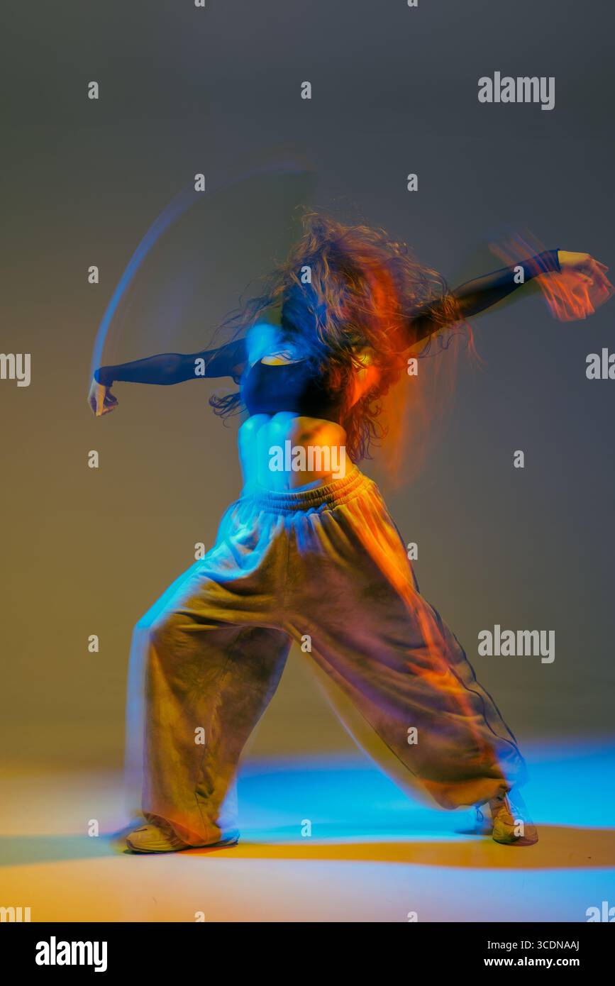 Energica ballerina jazz funk in movimento con luci audaci e coreografie creative, che mostrano uno stile di danza moderno e un movimento espressivo. Foto Stock