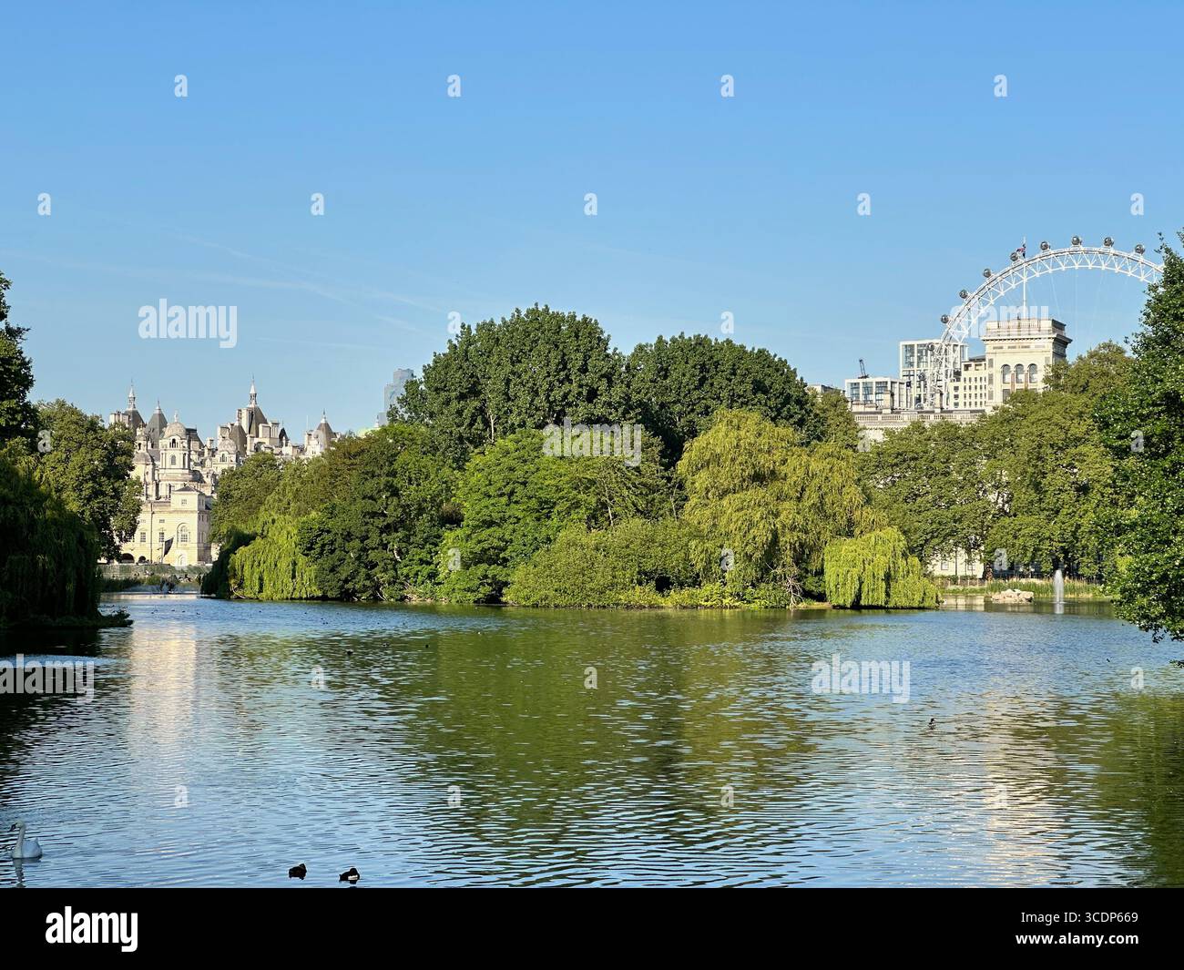 Lago St James's Park a Londra, Regno Unito, con l'edificio Horse Guards e il London Eye in lontananza sotto cieli azzurri. - Immagine stock catturata con smartphone