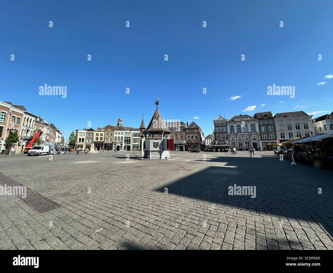 Ampia vista di piazza Vrijthof con la storica fontana Perroen e i tradizionali edifici olandesi sotto un cielo azzurro a Maastricht, Paesi Bassi. - Immagine stock catturata con smartphone
