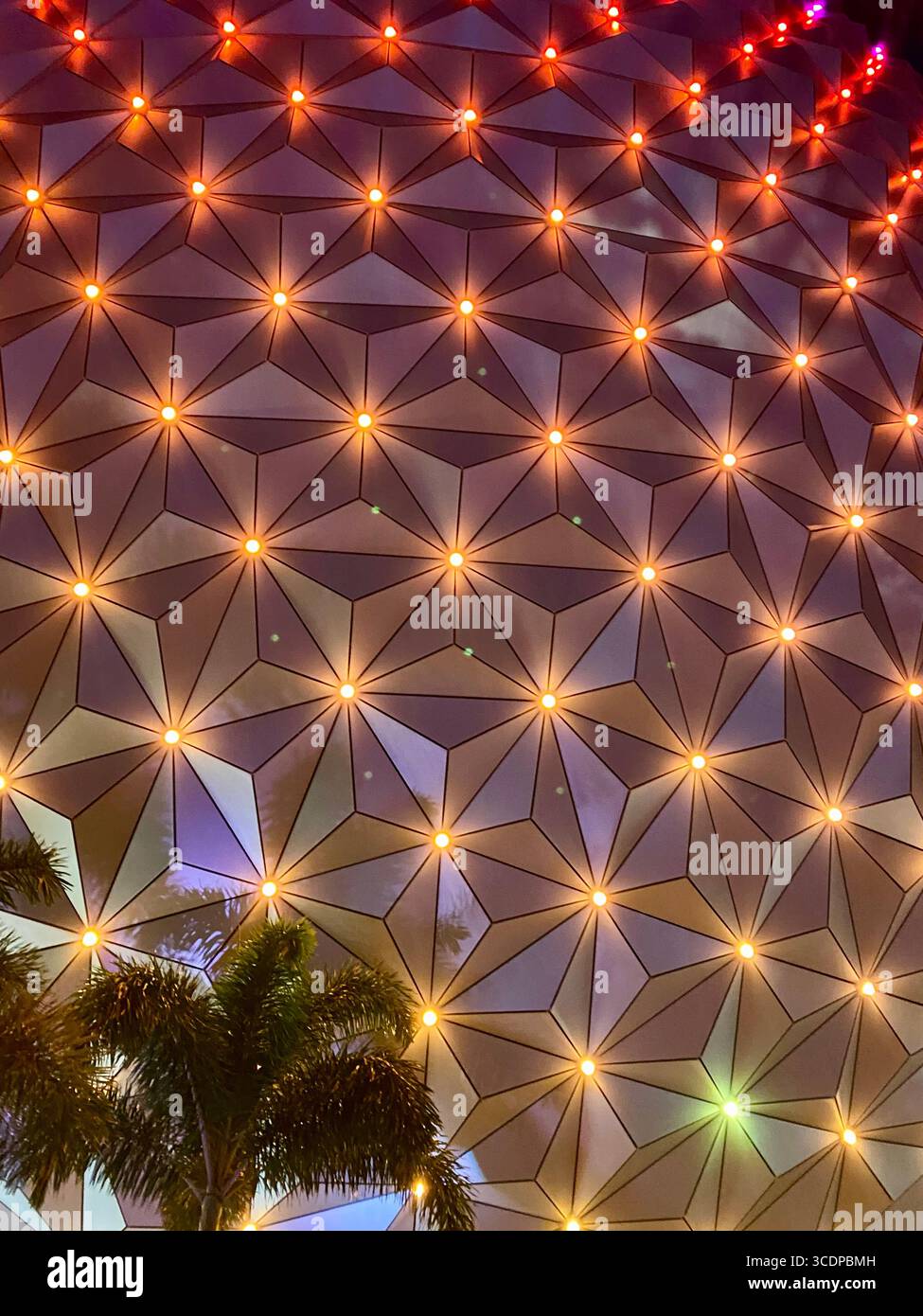 Dettagli ravvicinati dell'illuminazione serale sulla grande sfera iconica che ospita l'attrazione della Spaceship Earth. - Immagine stock catturata con smartphone