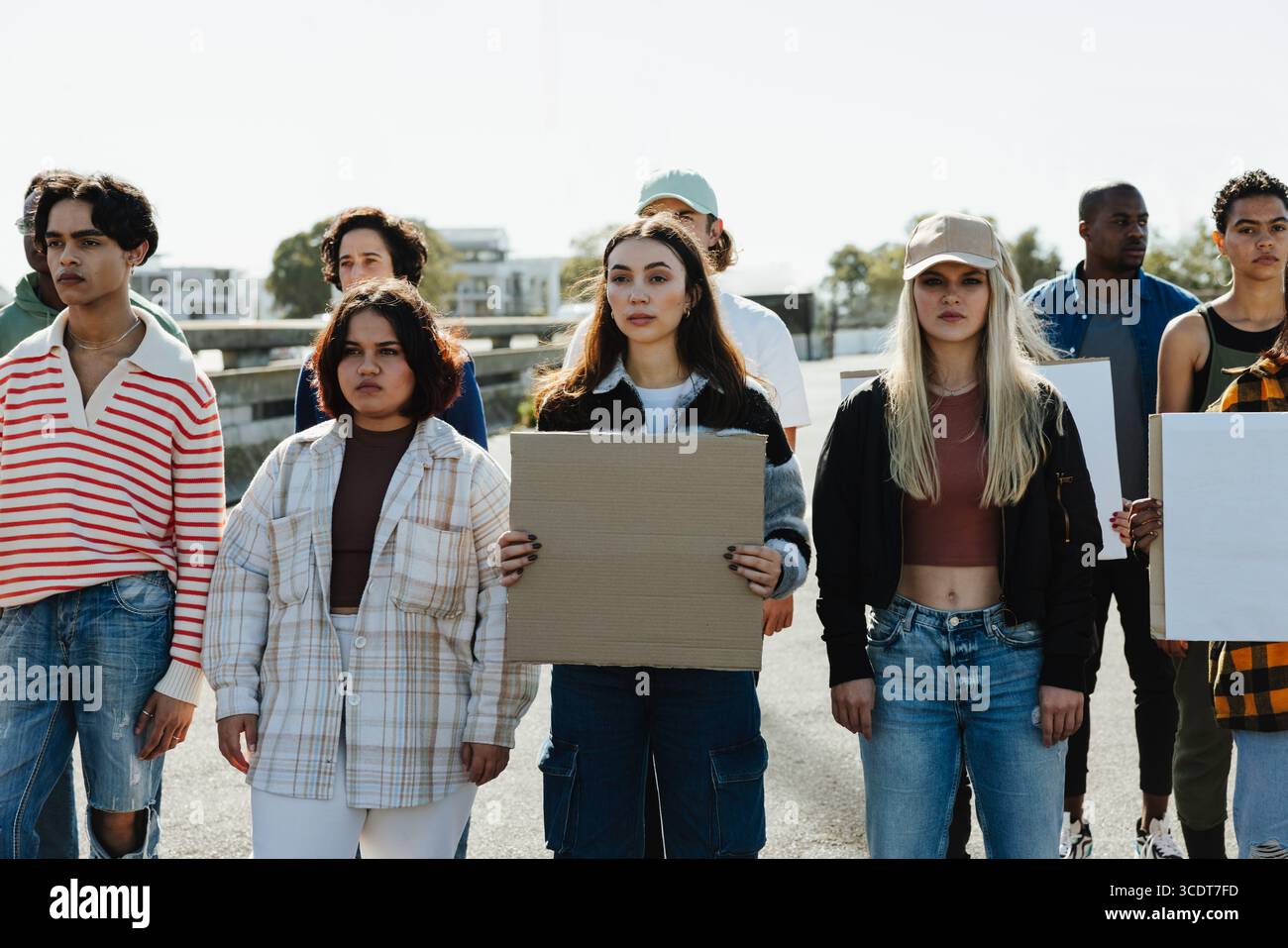 Un incontro diversificato di giovani adulti che tengono consigli di protesta, uniti in un ambiente urbano all'aperto, che trasmette unità e attivismo. Collaborazione A. Foto Stock