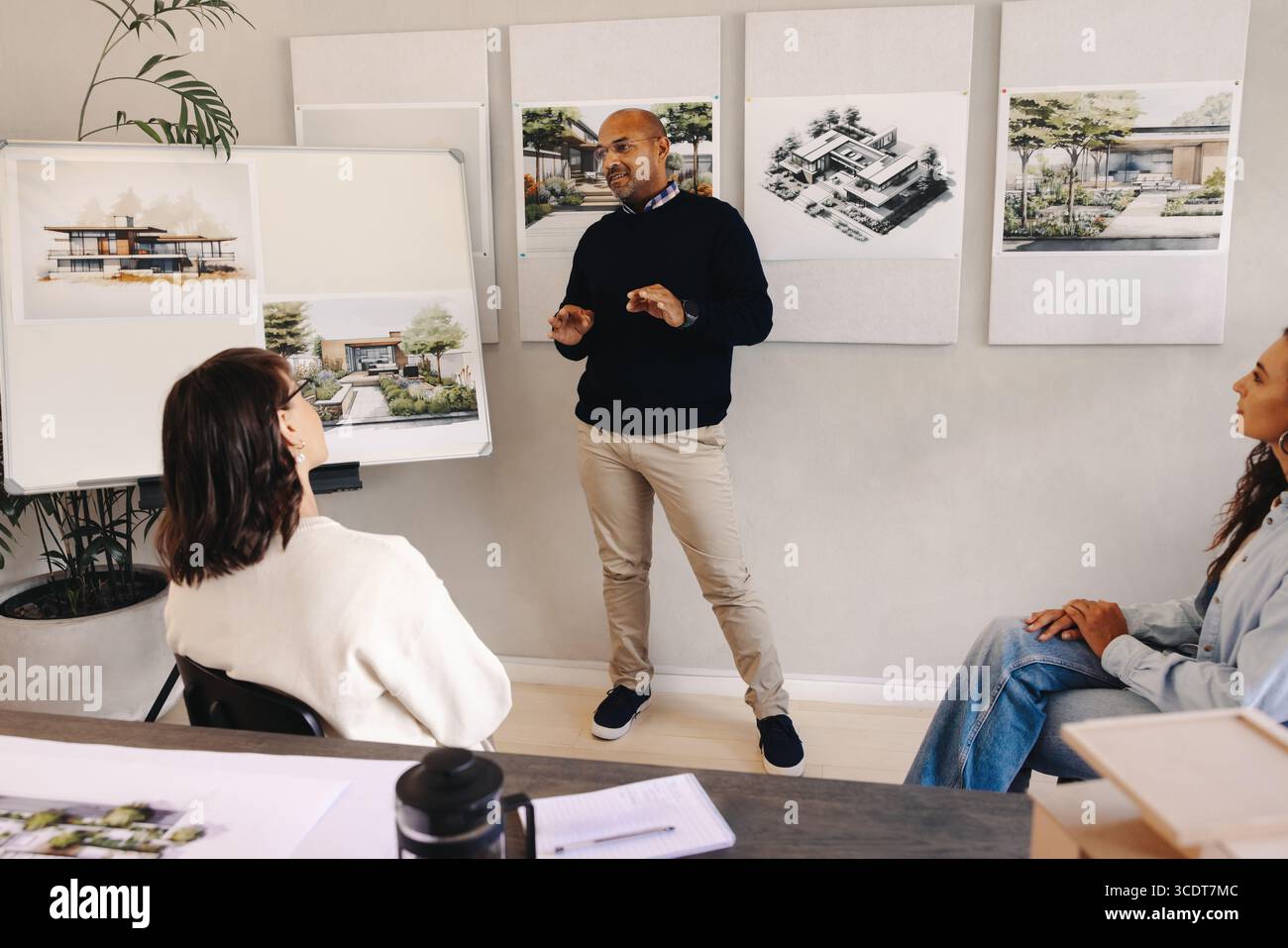 Il project manager presenta i concetti architettonici ai membri del team, discutendo in dettaglio le idee di un progetto. Foto Stock