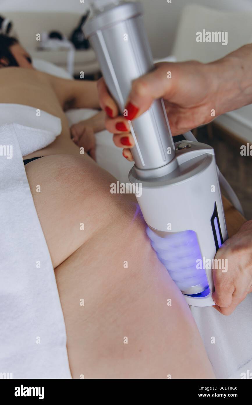 Trattamento di massaggio Endosphere anti cellulite su fianchi donna. Contorno del corpo, drenaggio linfatico, modellamento delle figure e terapia di rafforzamento della pelle in bellezza Foto Stock