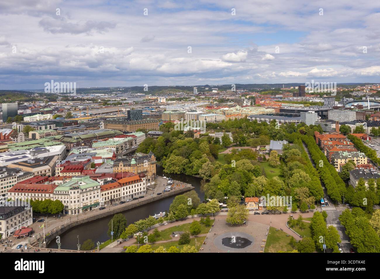 Vista aerea di parchi verdeggianti e corsi d'acqua che affettano l'arazzo urbano, edifici dipinti in terracotta e crema sotto un vasto cielo strutturato, Goteborg, Vastra Gotaland, Svezia. Foto Stock