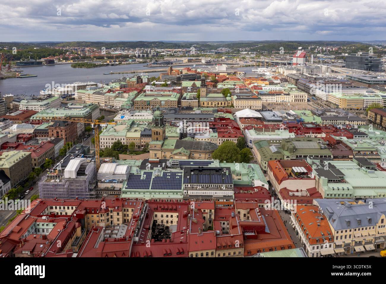 Vista aerea del vivace paesaggio urbano dove i tetti di terracotta si incontrano con un tranquillo porto sotto un vasto cielo nuvoloso, Goteborg, Vastra Gotaland, Svezia. Foto Stock