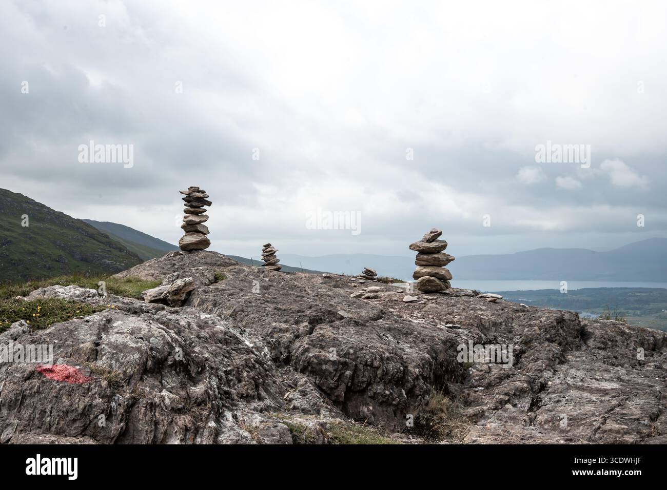 Pietre impilate disposte con cura su terreni rocciosi, splendidamente adagiate sotto un cielo nuvoloso Foto Stock