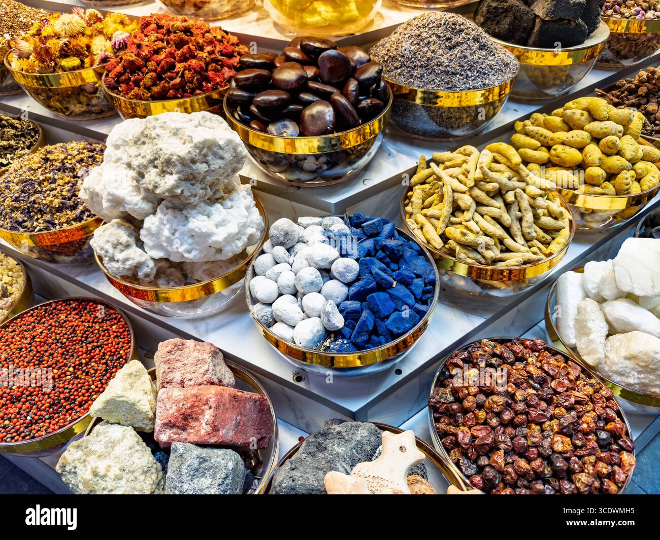 Varie spezie, erbe e minerali esposti in ciotole metalliche in un tradizionale mercato di souk delle spezie, Deira creek dubai emirati arabi uniti, colori e consistenze diversi - Immagine stock catturata con smartphone