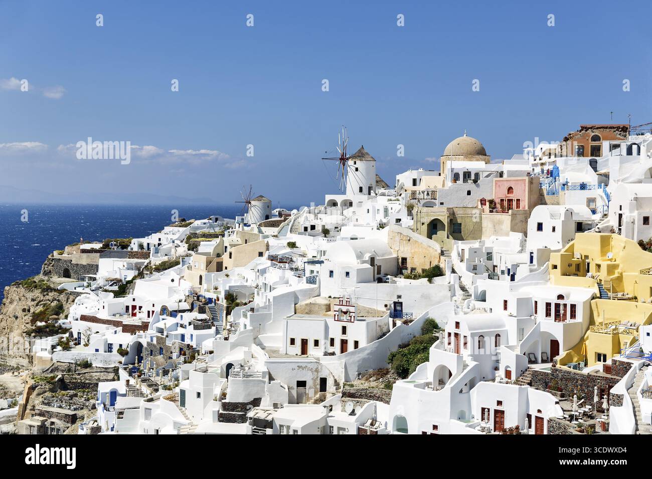 Case vacanza bianche e colorate su un pendio ripido, mulini a vento, vista di Oia, Thira, Santorini, Cicladi, Grecia Foto Stock