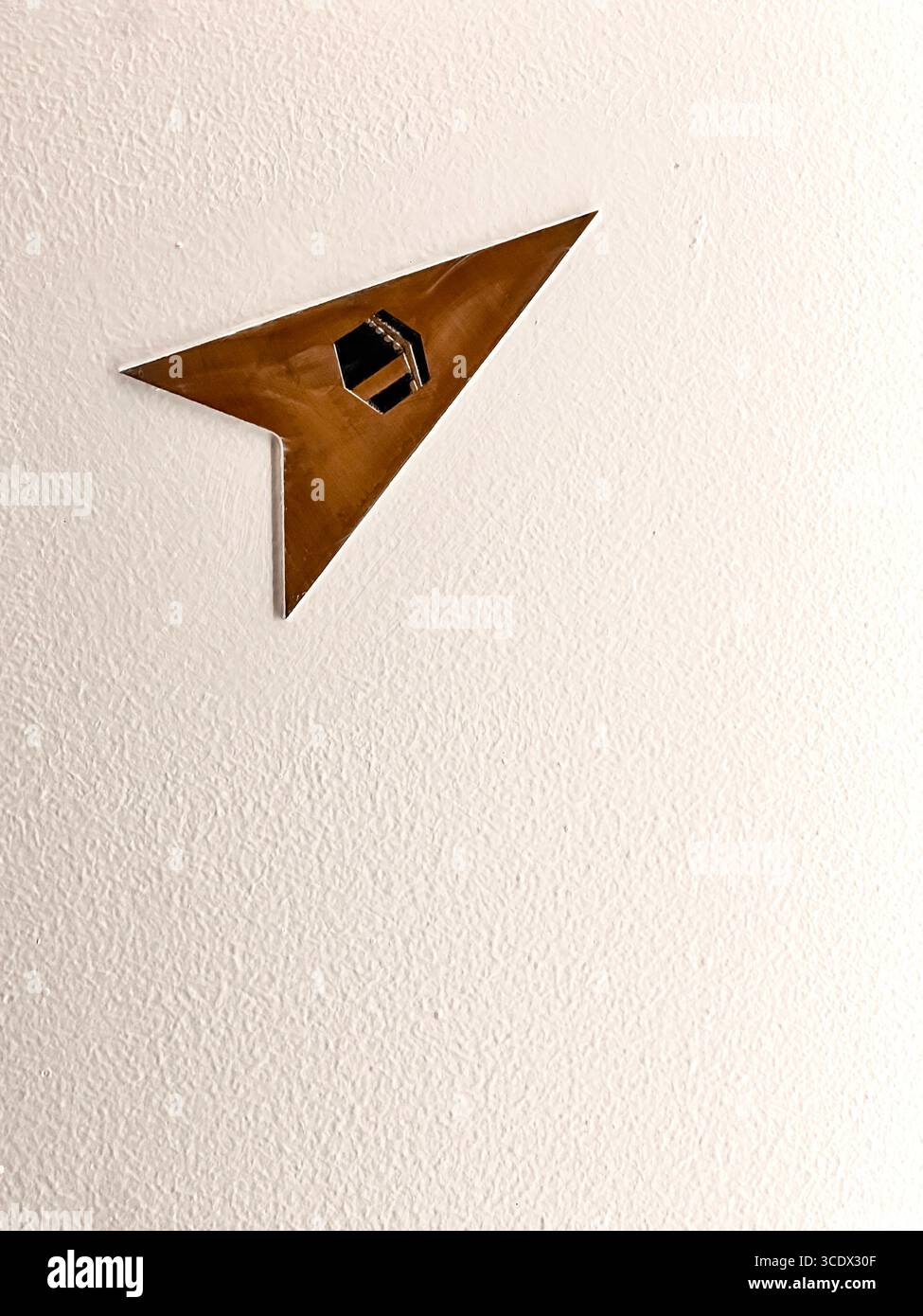 Freccia geometrica in legno sul soffitto testurizzato in un hotel di Dubai, Emirati Arabi Uniti che punta verso qibla alla mecca preghiera islamica di tradizione preghiere osservanza - Immagine stock catturata con smartphone