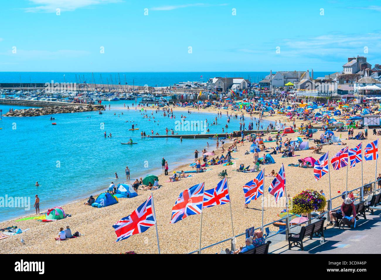 Lyme Regis, Dorset, Regno Unito. 14 agosto 2025. Meteo nel Regno Unito: I turisti affollano la spiaggia per crogiolarsi al sole caldo e glorioso nella località balneare di Lyme Regis. Crediti: Celia McMahon/Alamy Live News Foto Stock