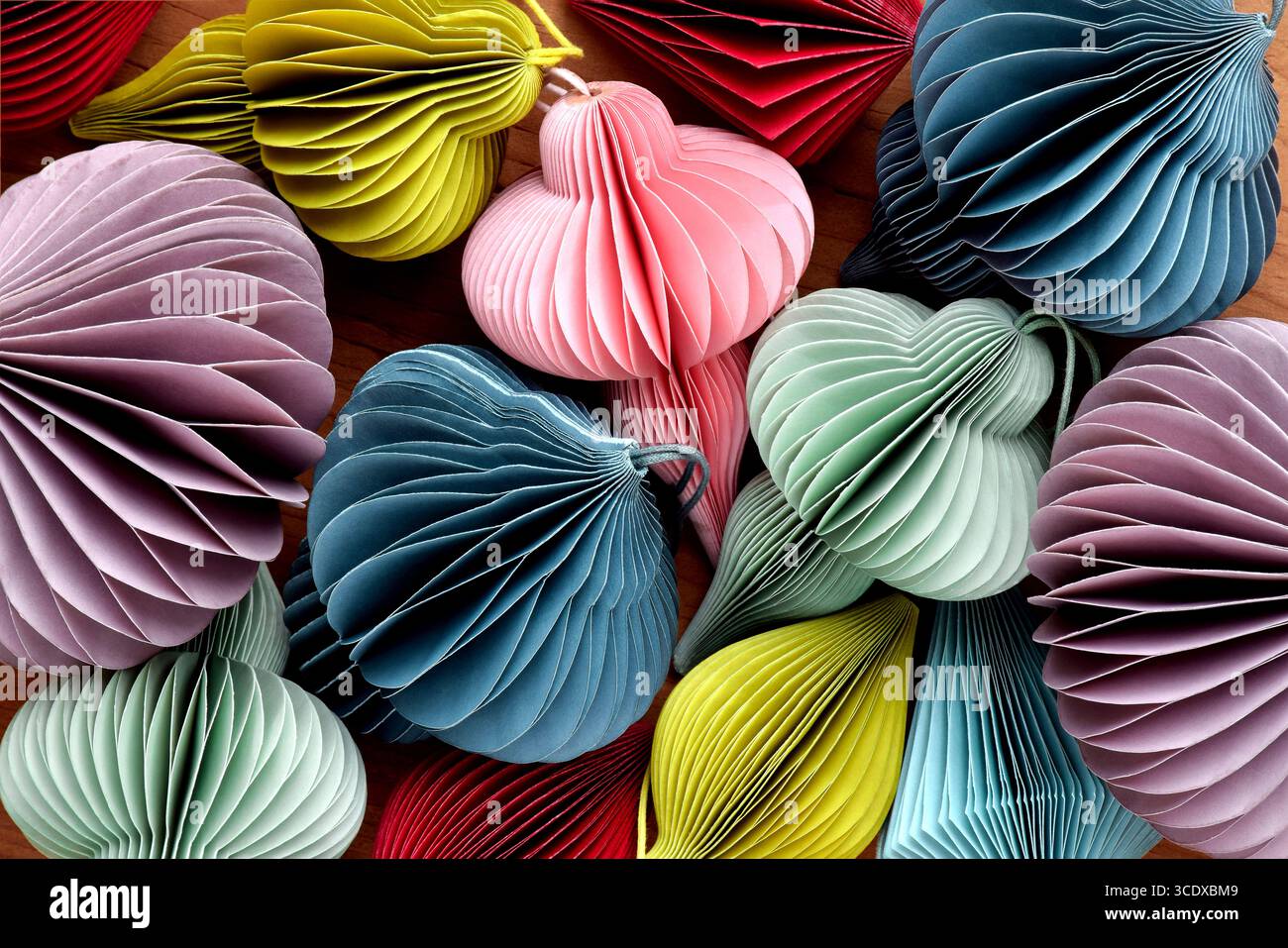 Gruppo di ornamenti natalizi multicolori fai da te in carta a nido d'ape si chiudono insieme Foto Stock