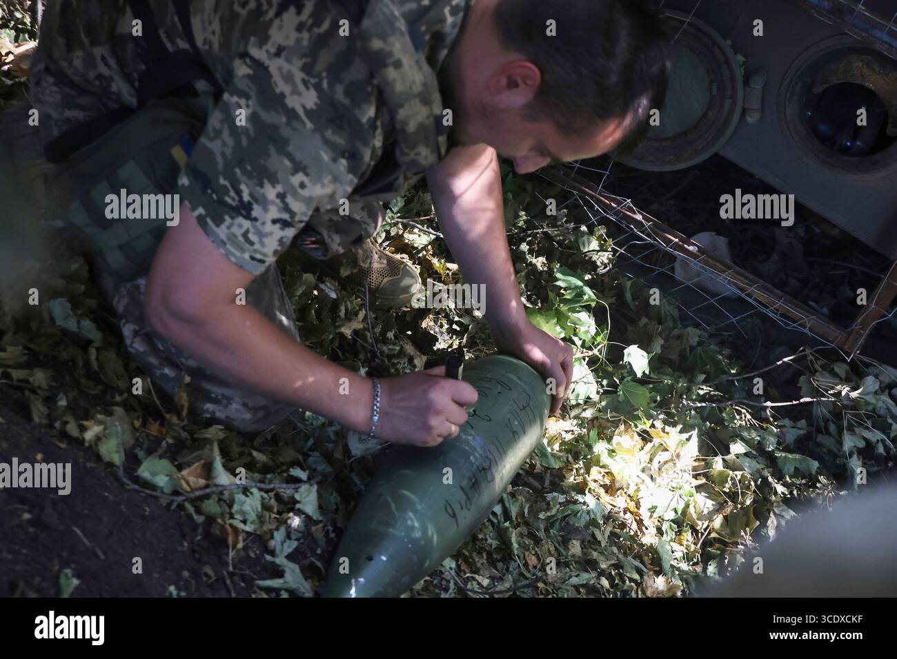 Un cannone di un'unità di artiglieria semovente 2S3 "Akatsiya" della 30a brigata meccanizzata separata intitolata al principe Kostiantyn Ostrozkyi firma un proiettile durante i preparativi per una missione di combattimento in direzione di Donetsk, Ucraina, il 13 agosto 2025 (foto di Viacheslav Madiievskyi/Ukrinform) Foto Stock