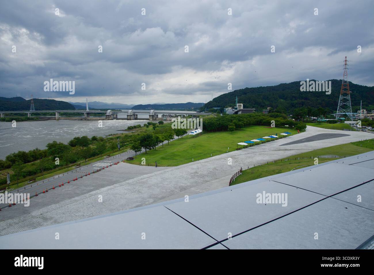 Vista dall'ARC sul fiume Nakdong verso la Gangjeong Goryeong Weir e i ponti adiacenti, mostrando lo spazio verde sul fiume, i sentieri e i padiglioni b Foto Stock