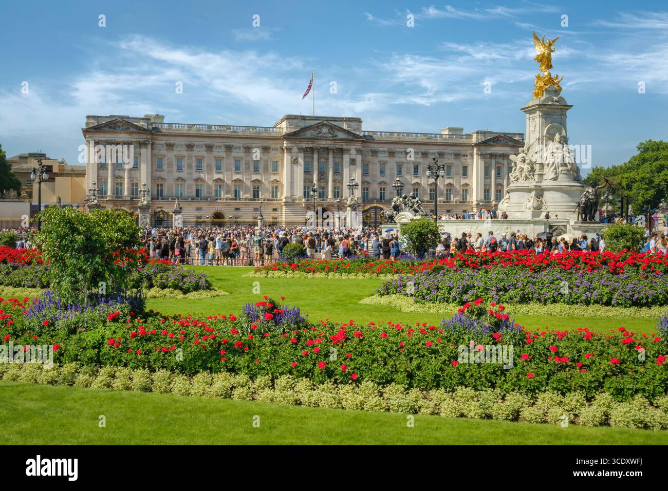 Londra, Inghilterra - in una calda giornata estiva, i turisti si riuniscono fuori Buckingham Palace nel centro di Londra. Foto Stock