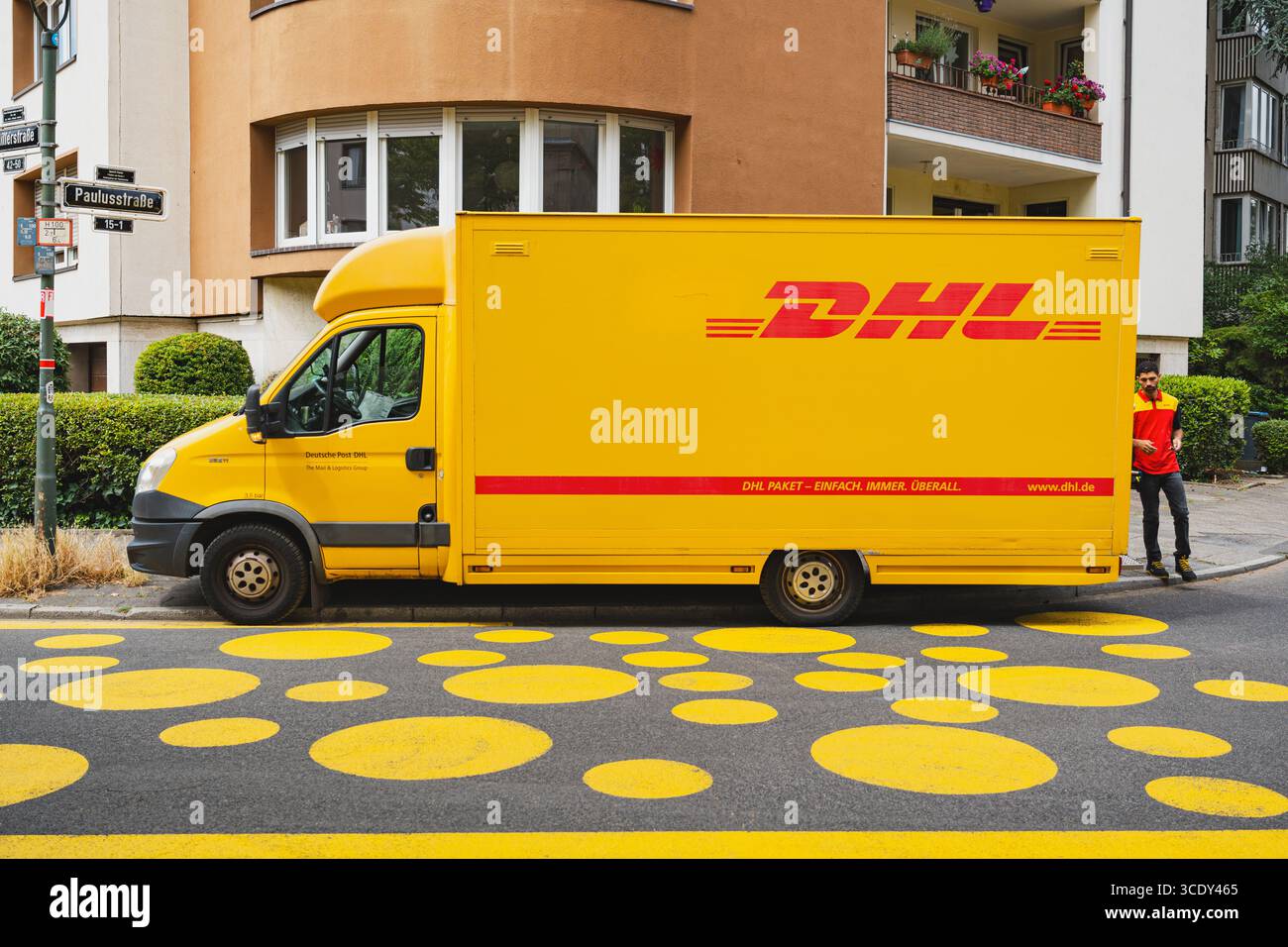Corriere DHL parcheggiato su una strada con un cerchio giallo Foto Stock