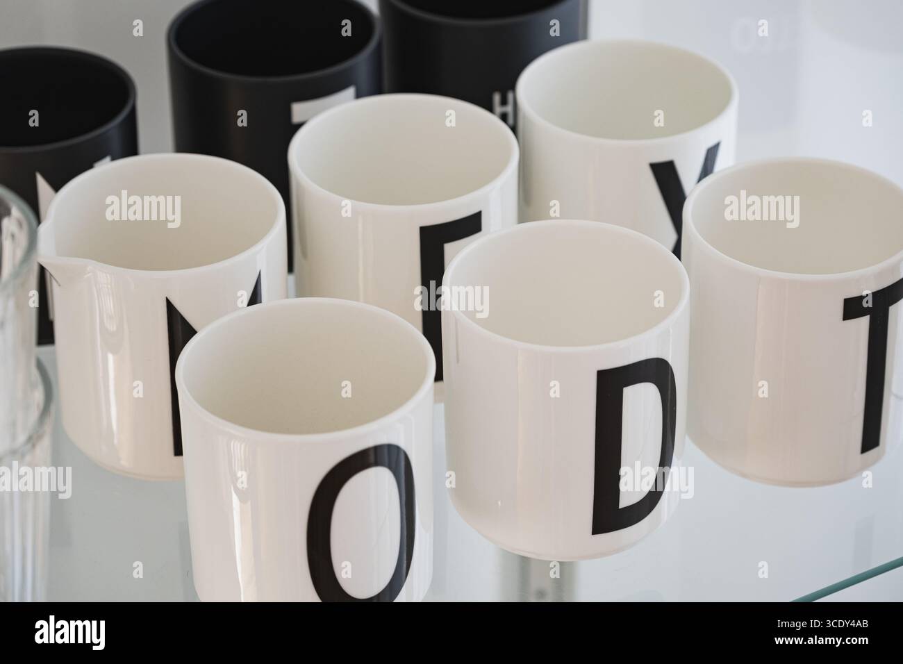 Tazze in bianco e nero dallo stile minimalista con stampe in grassetto sullo scaffale Foto Stock