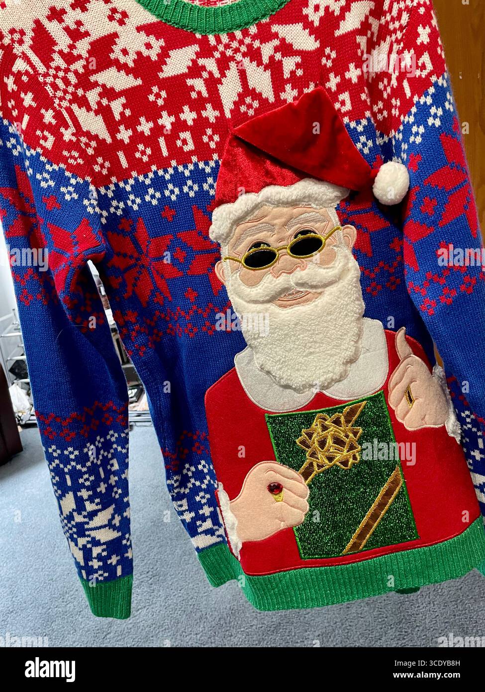 Primo piano di un brutto maglione natalizio pronto per una gara di kitschy, Stati Uniti, 2025 - Immagine stock catturata con smartphone