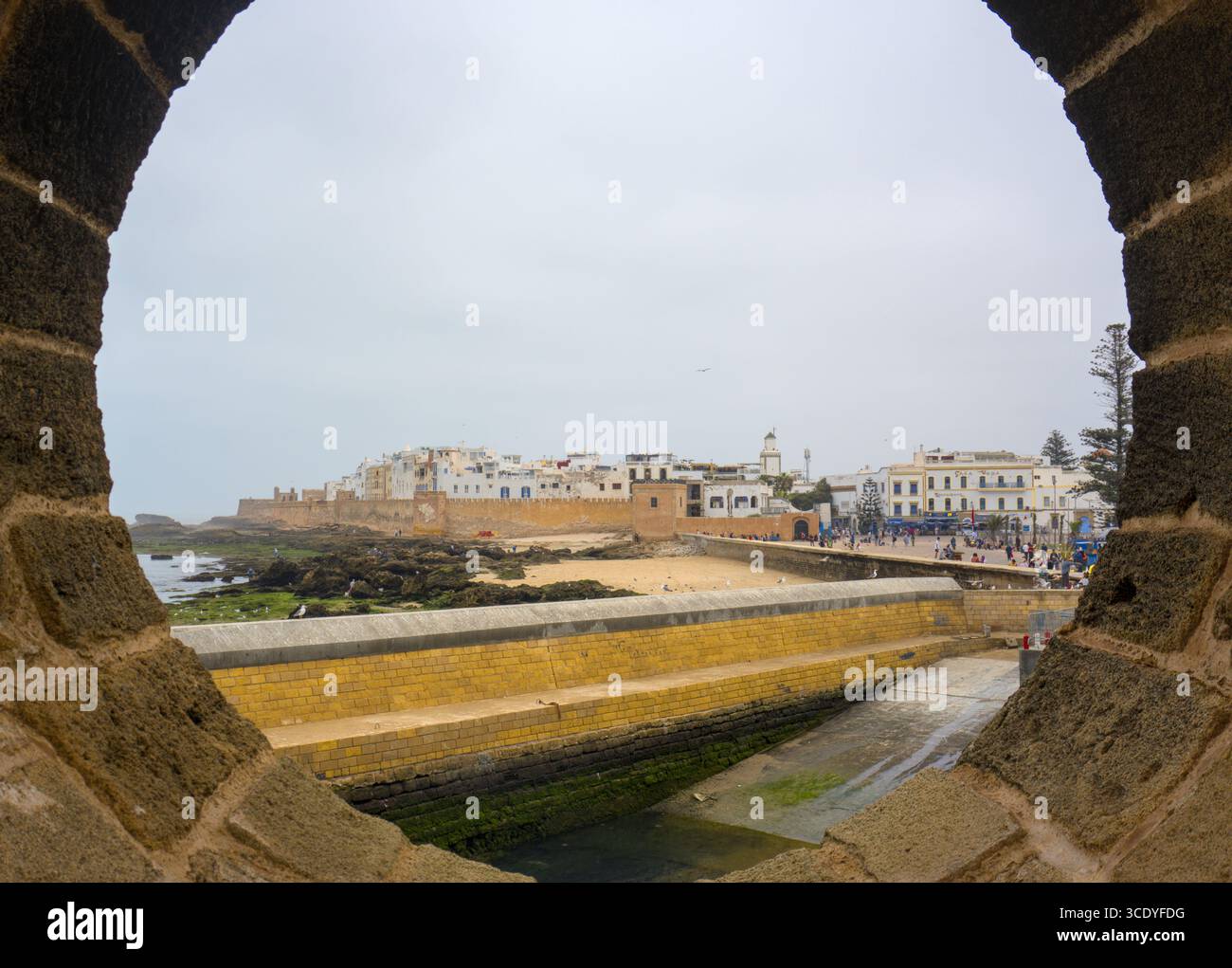 Guardando le vecchie mura della città di Essaouira attraverso un buco nei bastioni Foto Stock