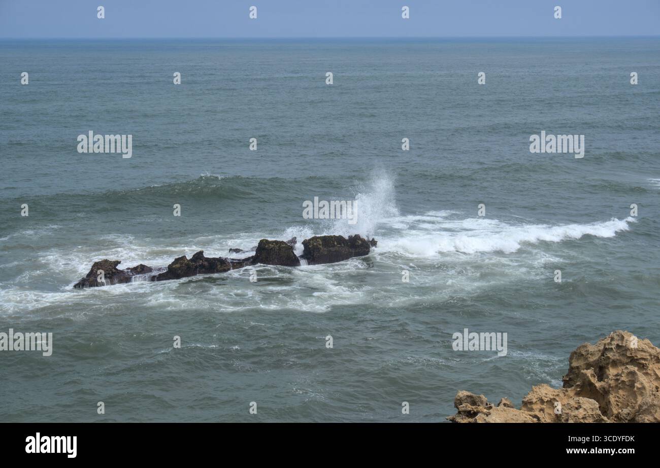 Onde che si infrangono su rocce a Mohammedia, in Marocco Foto Stock