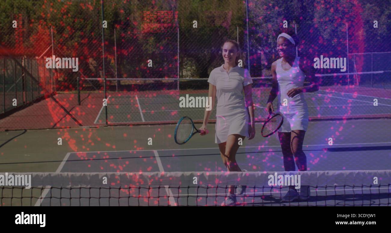 Due giocatori di tennis in abiti bianchi che chiacchierano e sorridevano sul campo duro all'aperto con racchette. Atletica leggera, lavoro di squadra, tempo libero, sportività, l Foto Stock