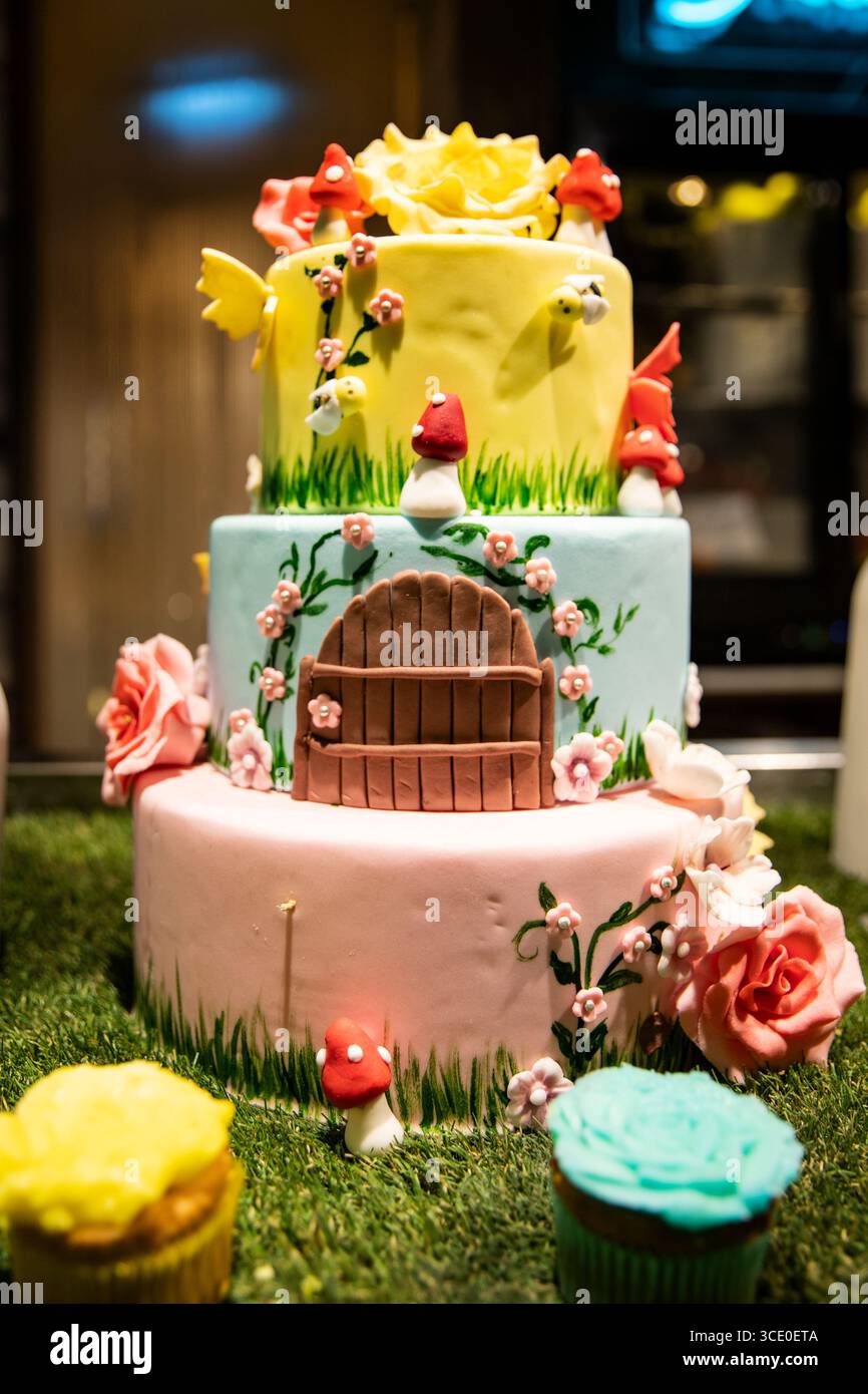 Pasticceria artistica, torta fata a più livelli con fiori e una porta per il compleanno dei bambini Foto Stock