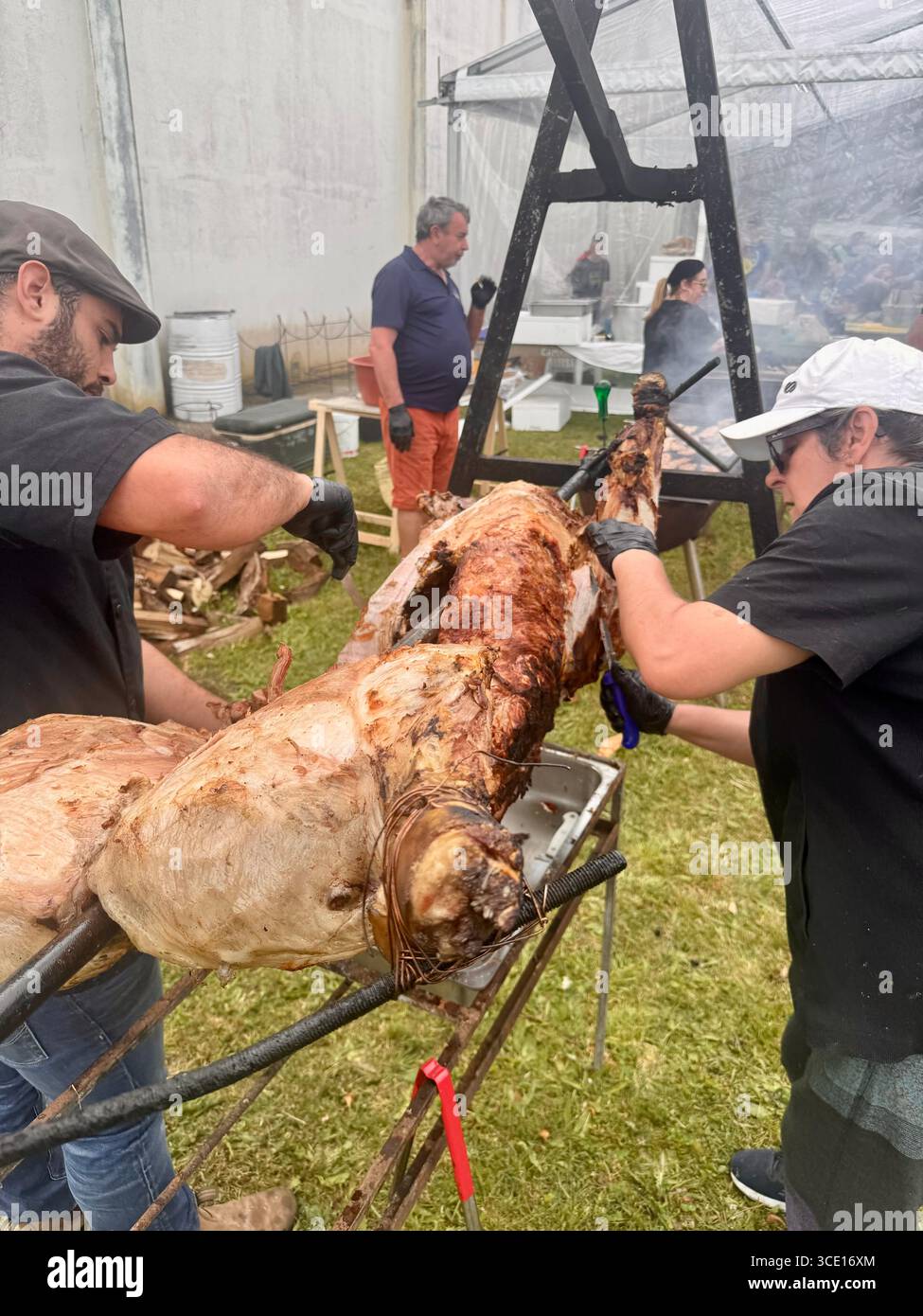 Arrosto di maiale allo spiedo come parte del pasto finale Trail Run Nordeste Real Priolo nelle Azzorre, Portogallo. - Immagine stock catturata con smartphone