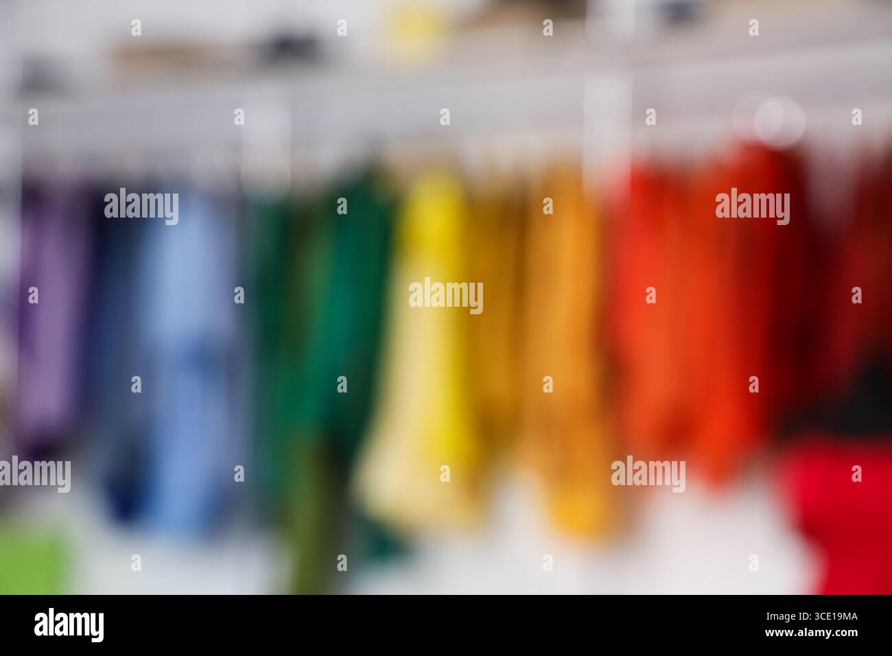 Vista sfocata dei vestiti colorati appesi nella boutique Foto Stock