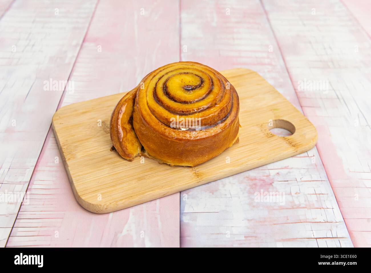 Tradizionali involtini alla cannella con crema di nocciole liscia e scaglie di nocciole tostate Foto Stock