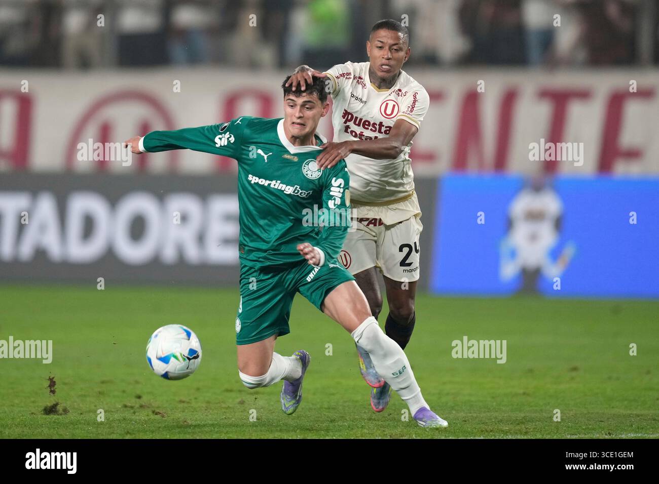Ramon Sosa of Brazil's Palmeiras is grabbed from behind by Andy Polo of Peru's Universitario de Deportesduring a Copa Libertadores round of sixteen first leg soccer match at Monumental stadium in Lima, Peru, Thursday, Aug. 14, 2025. (AP Photo/Martin Mejia) Foto Stock