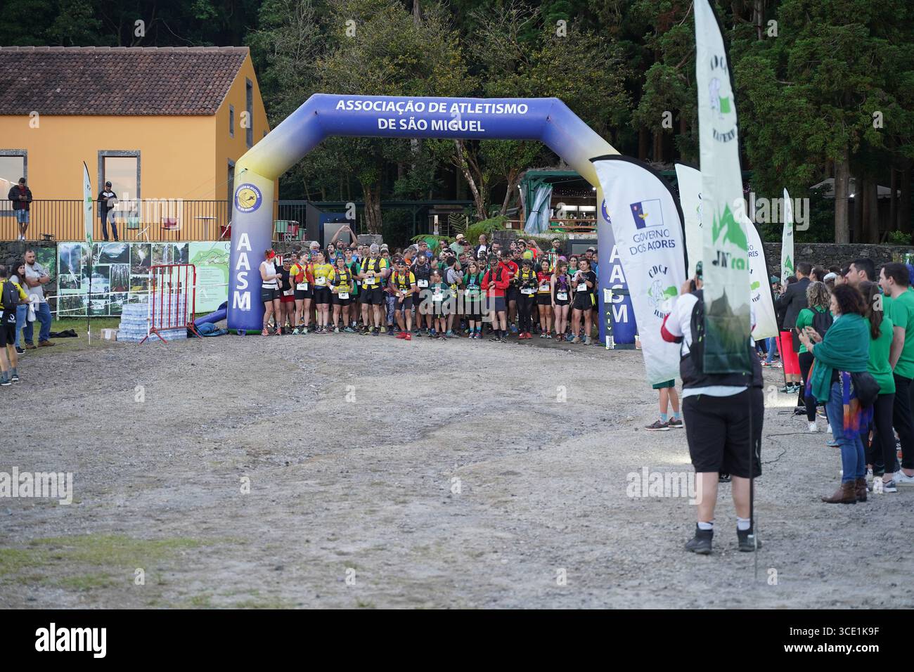 I corridori si riuniscono alla linea di partenza della mini gara di trail durante l'evento Furnas Night Trail, pronti a lanciarsi nella sfida notturna. Foto Stock