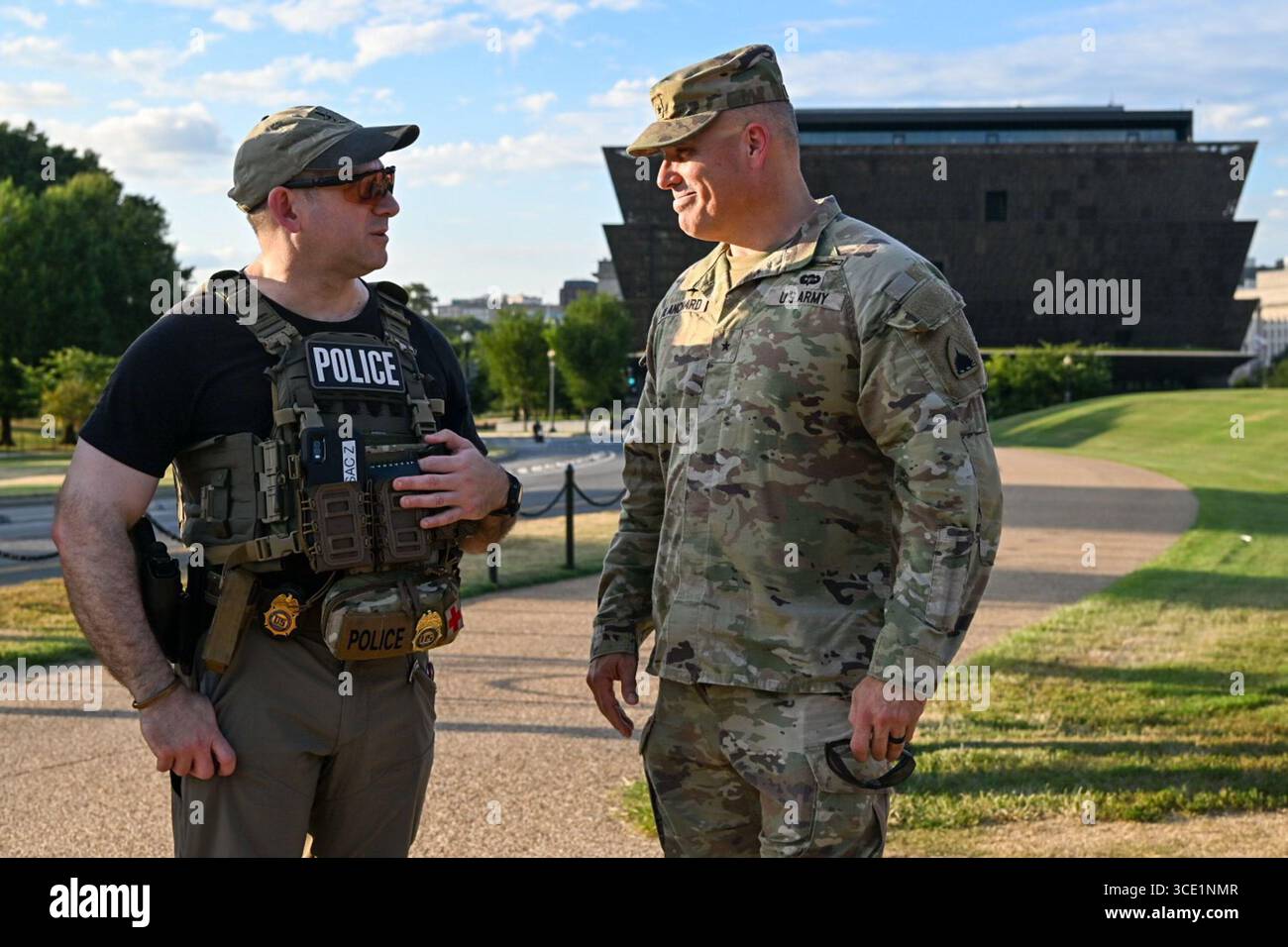 Brigantino dell'esercito degli Stati Uniti Il generale Leland D. Blanchard II, aiutante generale della Guardia Nazionale del Distretto di Columbia, parla con un agente della DEA durante le operazioni di pattuglia al National Mall, 12 agosto 2025. Il presidente Donald J. Trump ha attivato la Guardia Nazionale D.C. sotto il titolo 32 l'11 agosto 2025, per sostenere le forze dell'ordine federali e di Washington, D.C. all'interno della capitale della nazione. Per gentile concessione dell'esercito degli Stati Uniti. Foto Stock