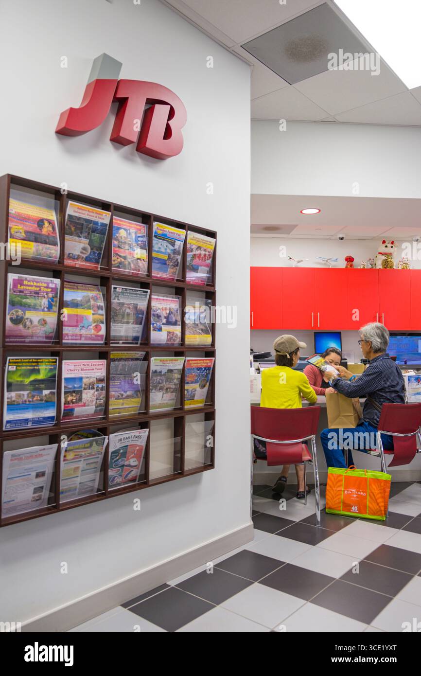 Agente di viaggio aiutando il cliente seduto alla scrivania all'interno della JTB office di Ala Moana Center, Honolulu Oahu, Hawaii, STATI UNITI D'AMERICA Foto Stock